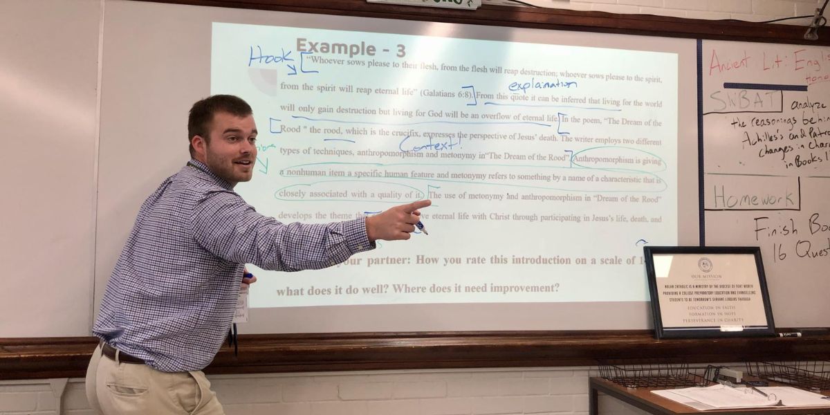 Teacher standing in front of a classroom, engaging with students.